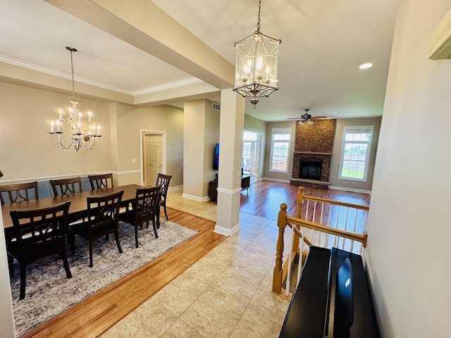 dining space with a chandelier, light wood-type flooring, a fireplace, ceiling fan, and baseboards