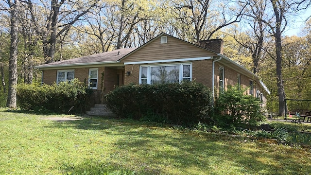 2119 E Exchange St, Crete, IL 60417 - view of front of home with a front lawn, brick siding, and a chimney