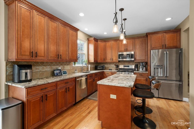 10650 Painted Desert Ct, Huntley, IL 60142 - kitchen featuring appliances with stainless steel finishes, a sink, light wood-type flooring, brown cabinets, and backsplash