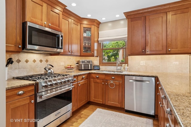 16 Rock River Ct, Naperville, IL 60565 - kitchen with stainless steel appliances, a sink, brown cabinetry, light stone counters, and recessed lighting