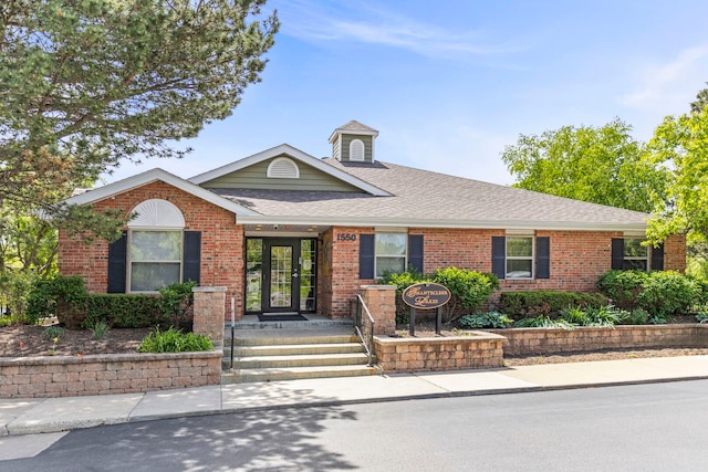 single story home featuring brick siding and a shingled roof