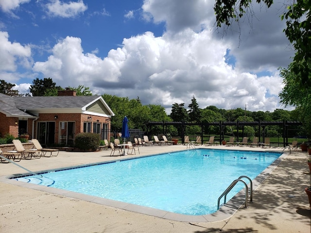 community pool with fence and a patio