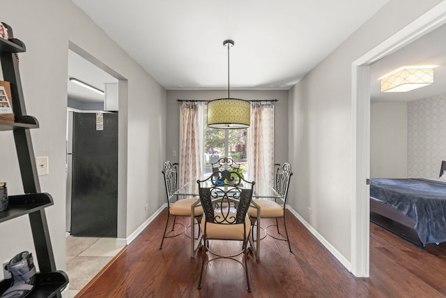 dining space with wood finished floors and baseboards