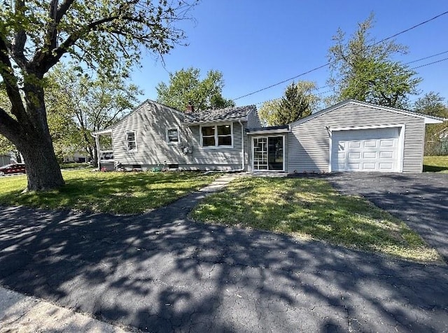 view of front of property featuring driveway, a front yard, a chimney, and a garage