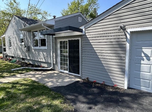 back of property featuring a garage and a patio area