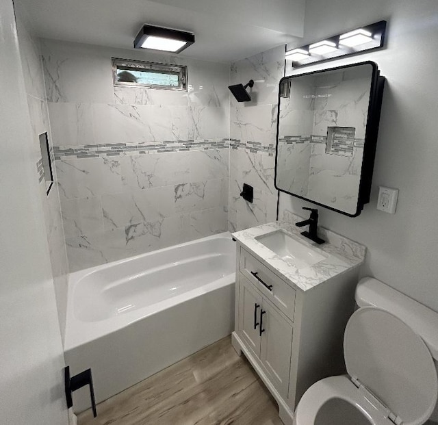 full bath with toilet, wood finished floors, bathtub / shower combination, and vanity