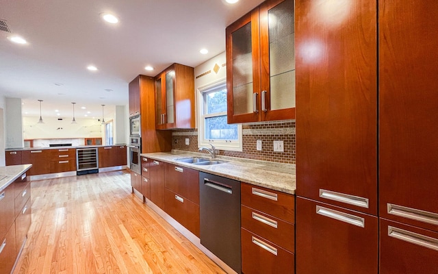 kitchen with a sink, appliances with stainless steel finishes, beverage cooler, brown cabinets, and recessed lighting
