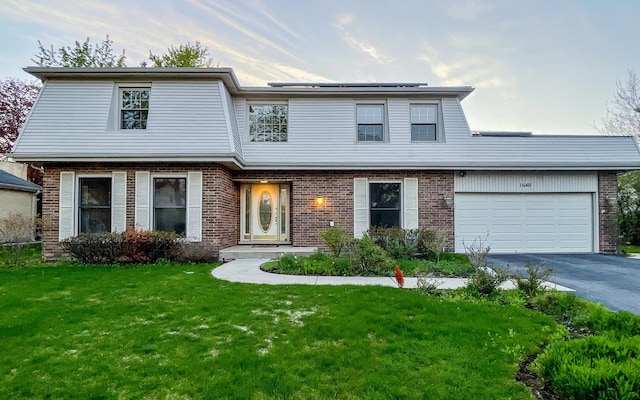 view of front facade with brick siding, asphalt driveway, and a garage