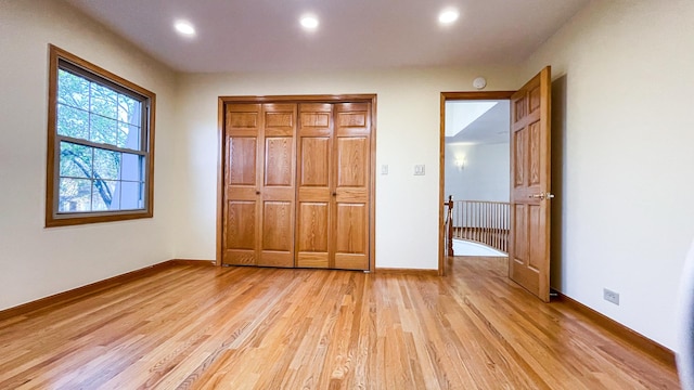 unfurnished bedroom with light wood-type flooring, recessed lighting, a closet, and baseboards