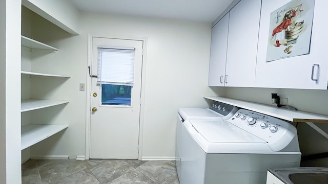 washroom featuring cabinet space, washer and clothes dryer, and baseboards