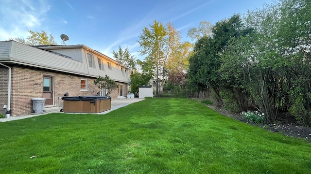 view of green lawn with a hot tub