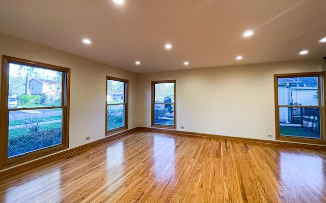 empty room featuring light wood-style floors, recessed lighting, and baseboards