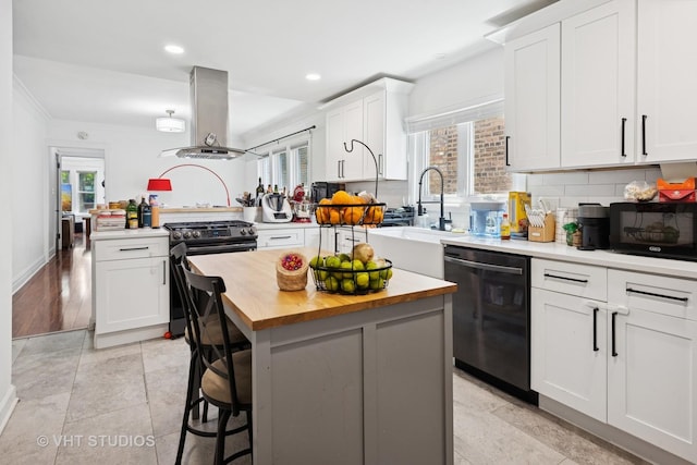 5814 N Campbell Ave, Chicago, IL 60659 - kitchen featuring dishwashing machine, stainless steel gas range oven, island range hood, black microwave, and butcher block countertops
