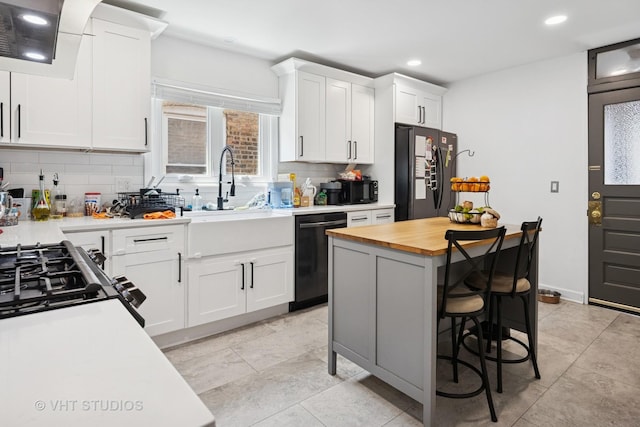 5814 N Campbell Ave, Chicago, IL 60659 - kitchen with dishwashing machine, freestanding refrigerator, wood counters, decorative backsplash, and white cabinetry