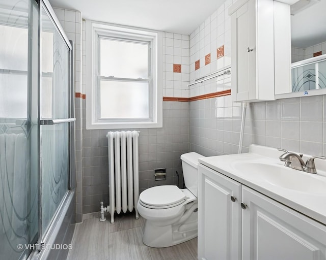 5814 N Campbell Ave, Chicago, IL 60659 - bathroom featuring radiator, tile walls, vanity, and enclosed tub / shower combo