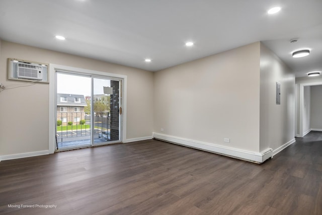 spare room featuring baseboard heating, a wall mounted AC, dark wood-type flooring, baseboards, and recessed lighting