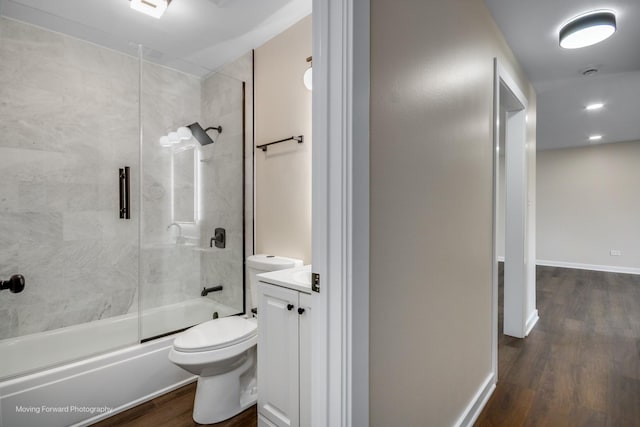 bathroom with wood finished floors, enclosed tub / shower combo, toilet, and vanity