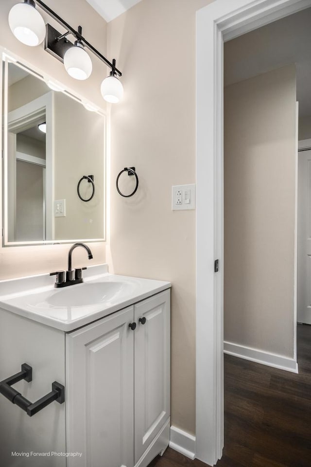 bathroom featuring wood finished floors, vanity, and baseboards