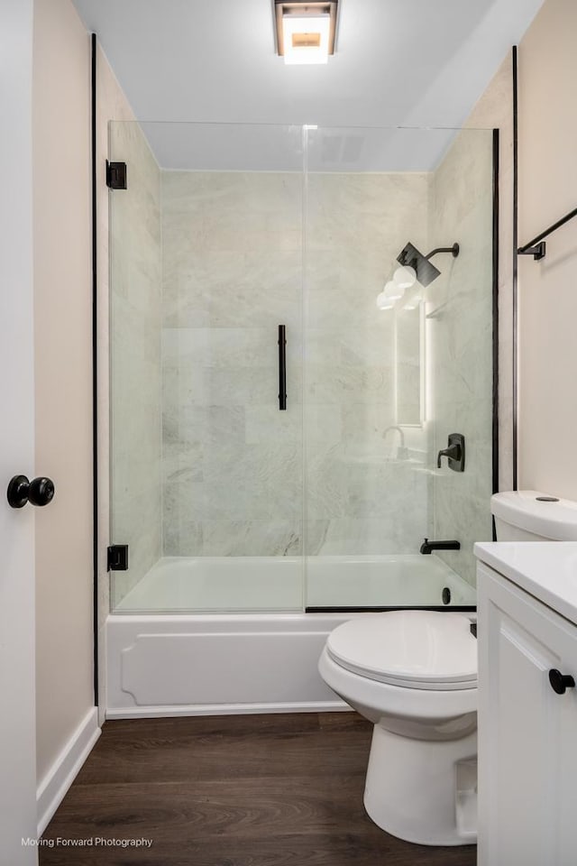 full bath with wood finished floors, toilet, enclosed tub / shower combo, and vanity