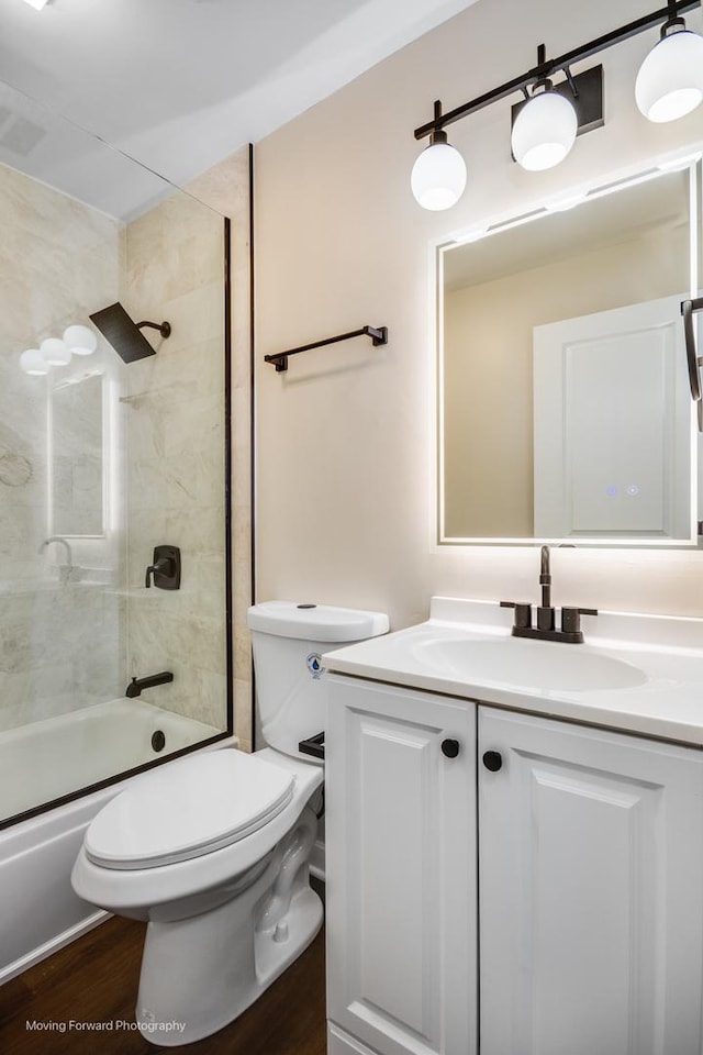 bathroom featuring vanity, shower / bath combination with glass door, toilet, and wood finished floors