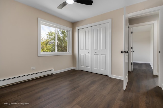 unfurnished bedroom with a baseboard radiator, dark wood-type flooring, baseboards, a closet, and ceiling fan