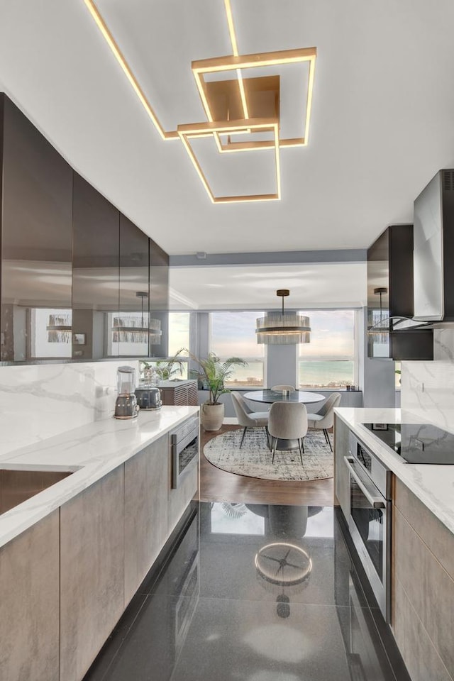 2626 N Lakeview Ave Unit 2703, Chicago, IL 60614 - kitchen featuring stainless steel oven, modern cabinets, black electric cooktop, light stone counters, and wall chimney exhaust hood