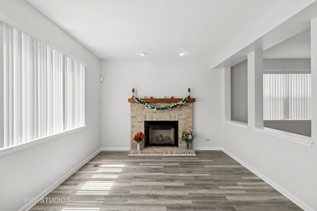 667 W Jonathan Dr, Round Lake, IL 60073 - unfurnished living room featuring healthy amount of natural light, a brick fireplace, and wood finished floors