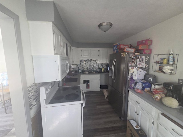 kitchen featuring white appliances, a sink, white cabinetry, and decorative backsplash