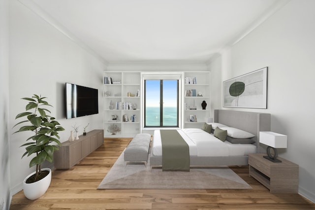 bedroom with light wood-type flooring and ornamental molding