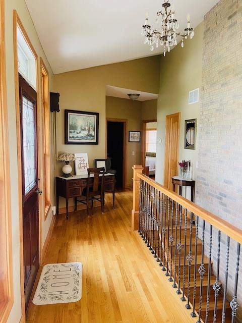1976 E 24th Rd, Ransom, IL 60470 - corridor with light wood finished floors, an upstairs landing, a chandelier, high vaulted ceiling, and baseboards