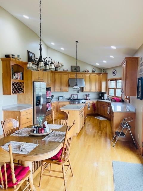 1976 E 24th Rd, Ransom, IL 60470 - kitchen with appliances with stainless steel finishes, vaulted ceiling, open shelves, range hood, and light wood-style flooring