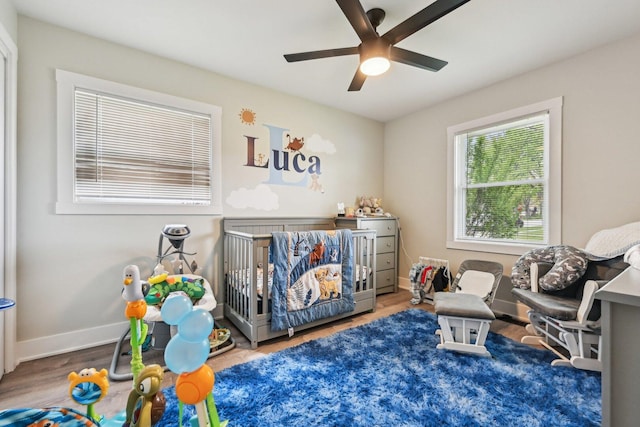 700 Delphia Ave, Elk Grove Village, IL 60007 - bedroom featuring wood finished floors, ceiling fan, baseboards, and a crib