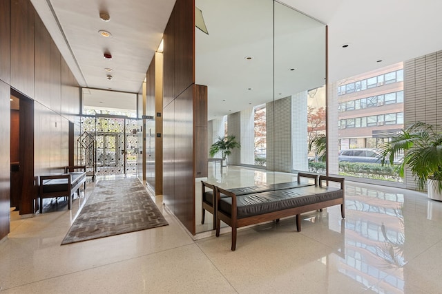 common area with a high ceiling and a wall of windows