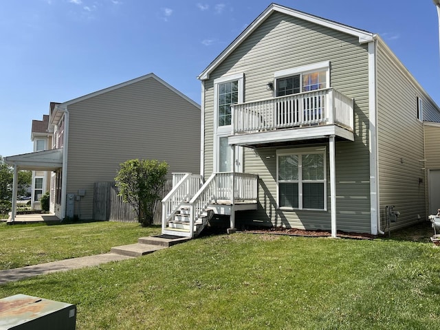rear view of property with a balcony and a yard
