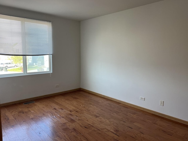 empty room featuring wood finished floors and baseboards