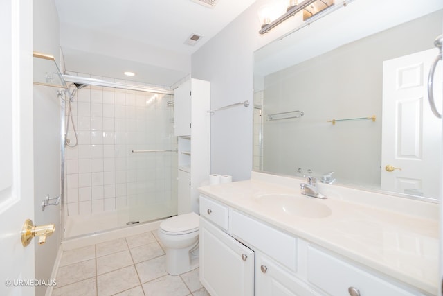 full bath featuring tile patterned flooring, toilet, tiled shower, and vanity