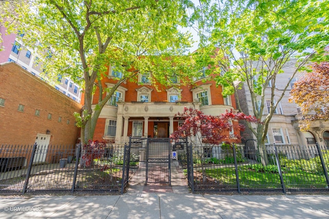 multi unit property featuring a fenced front yard and a gate