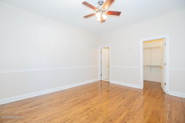 spare room with ceiling fan, light wood-style flooring, and baseboards