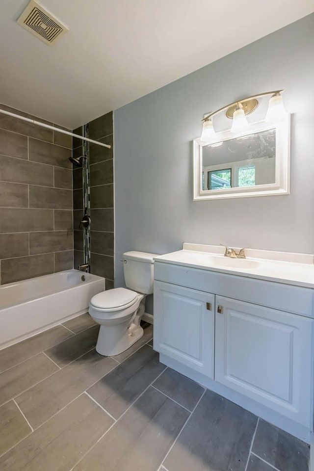 full bathroom featuring toilet, vanity, washtub / shower combination, and tile patterned flooring