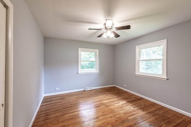 spare room with wood finished floors, baseboards, and ceiling fan