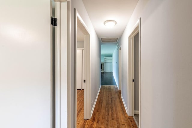 hallway with wood finished floors and baseboards