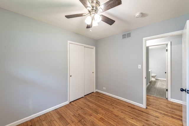 unfurnished bedroom featuring light wood-style floors, baseboards, a closet, and a ceiling fan