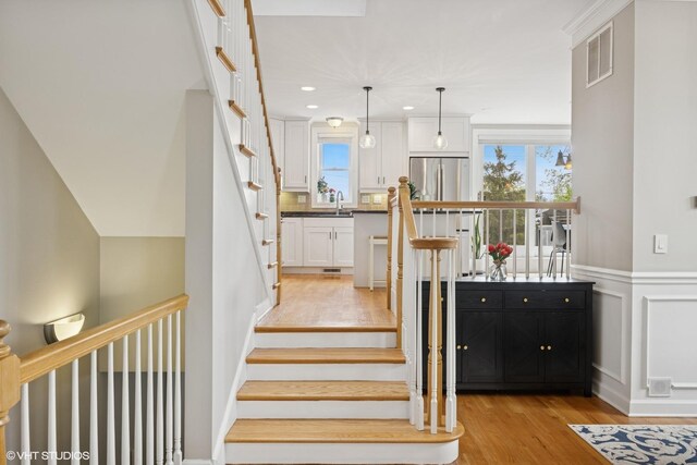 209 S Evergreen Ave, Arlington Heights, IL 60005 - staircase featuring wood finished floors, wainscoting, recessed lighting, and a decorative wall