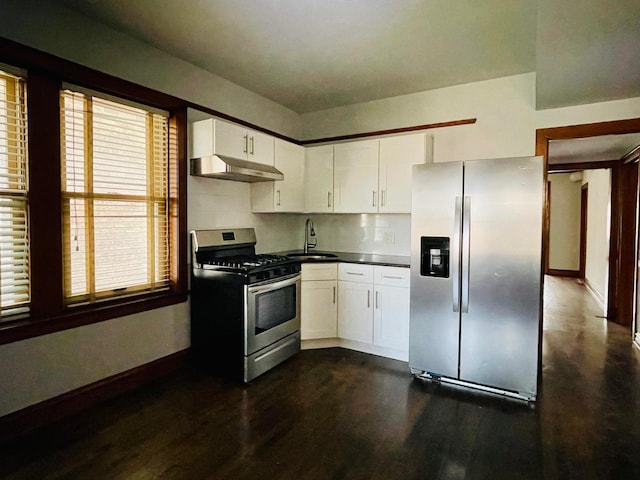4623 S Harding Ave, Chicago, IL 60632 - kitchen featuring appliances with stainless steel finishes, under cabinet range hood, a sink, dark wood-style flooring, and dark countertops