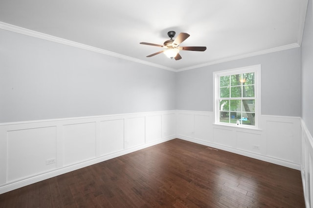 empty room with ceiling fan, wainscoting, crown molding, and wood finished floors