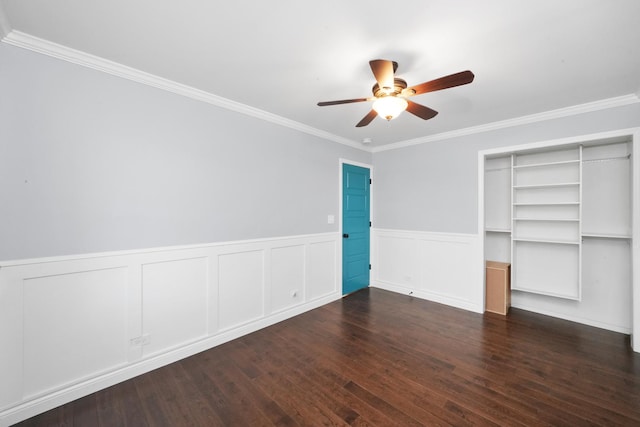 unfurnished bedroom featuring wainscoting, ornamental molding, wood finished floors, a ceiling fan, and a closet