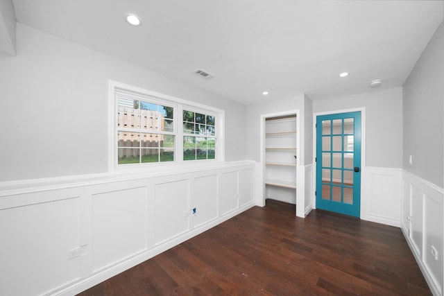 unfurnished room featuring wainscoting, a decorative wall, dark wood-style floors, and recessed lighting