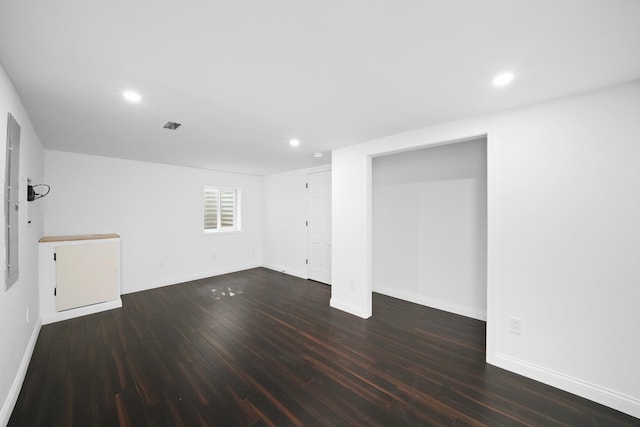 empty room featuring dark wood-style floors, baseboards, and recessed lighting