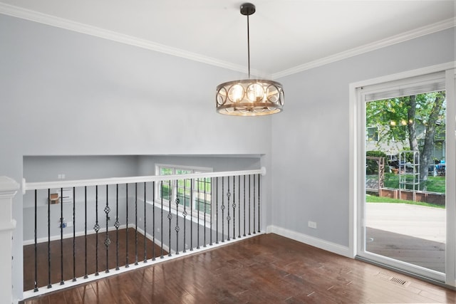 unfurnished room featuring wood finished floors, crown molding, baseboards, and a chandelier
