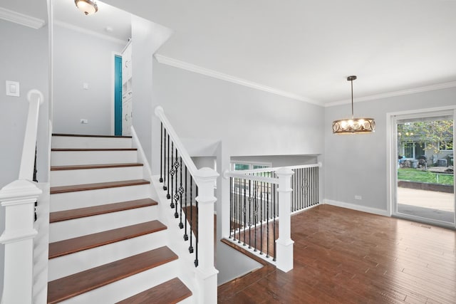 stairs featuring crown molding, wood finished floors, and baseboards